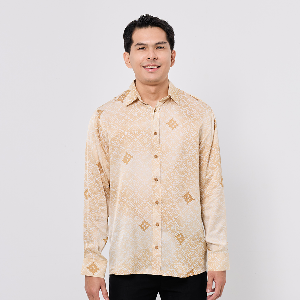 Man wearing a beige patterned shirt against a white background