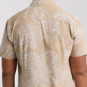 Beige shirt with white floral pattern on a plain background