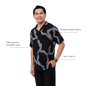 Man wearing batik shirt with black chain-like patterns