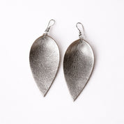 Pair of silver leaf-shaped earrings on a white background