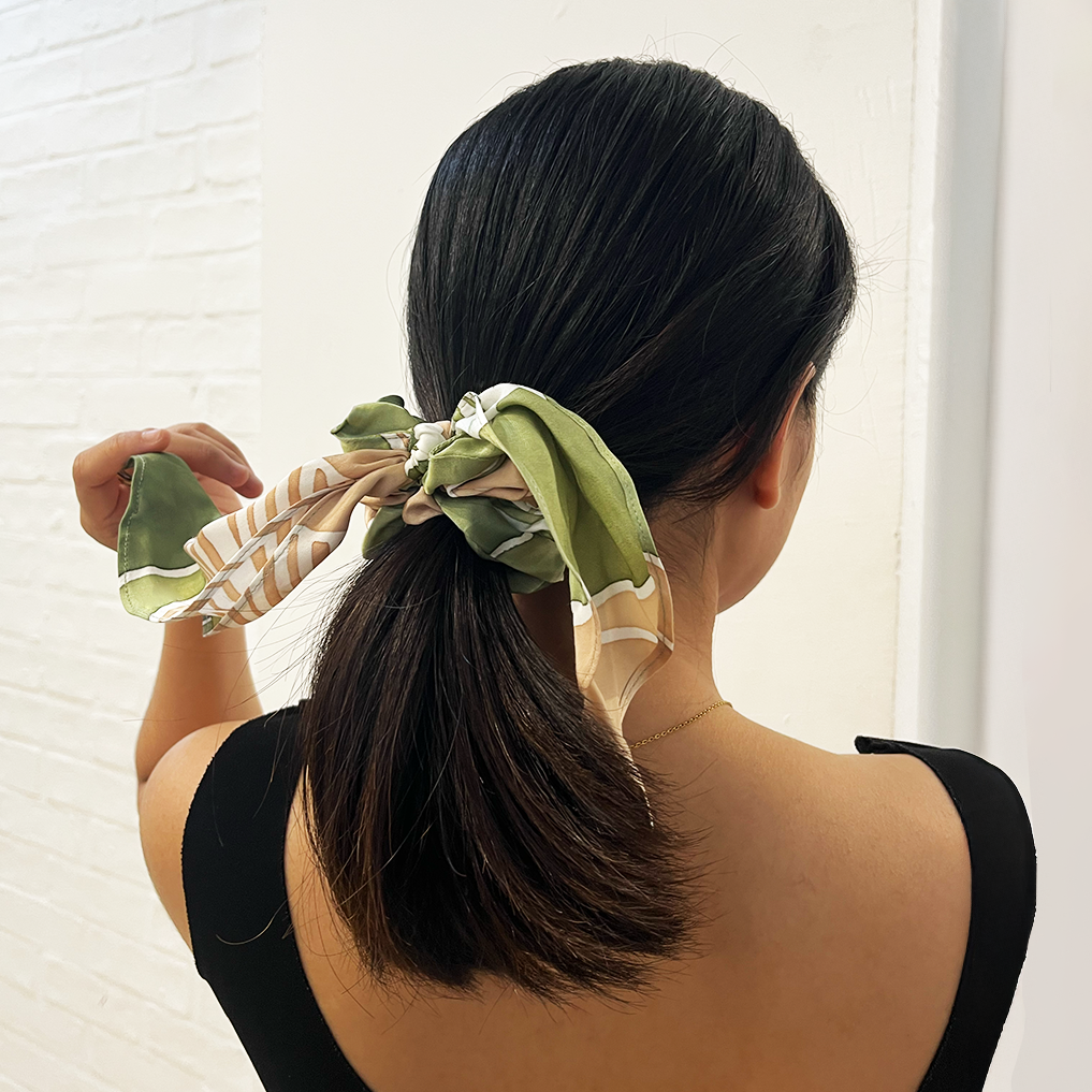 Woman wearing Moss Bukit batik scrunchie with ribbon tail.