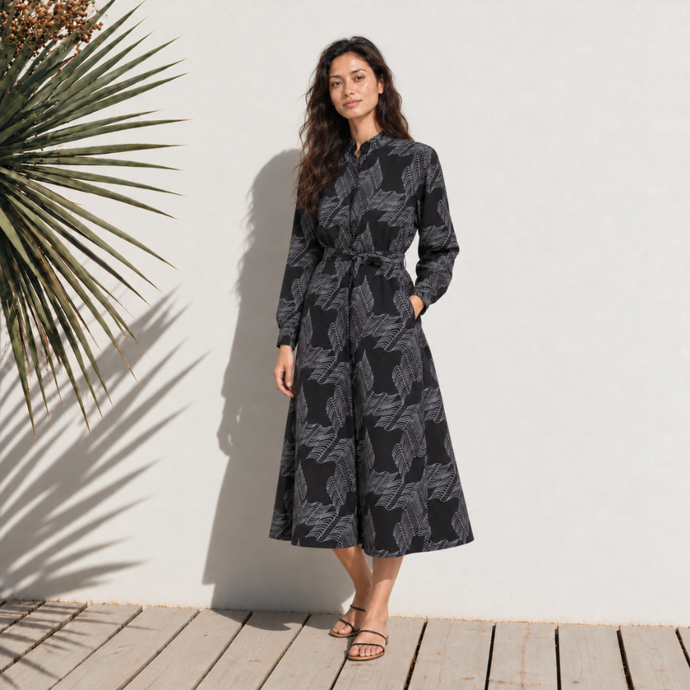 Woman wearing black printed batik dress standing outside