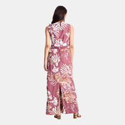 A woman viewed from the back wearing a sleeveless midi dress with a white and light maroon abstract pattern and a matching tie belt at the waist, set against a plain light gray studio background.
