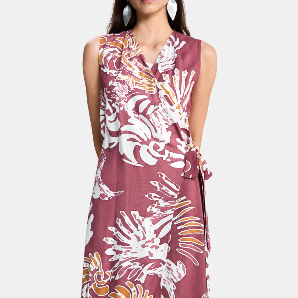 A sleeveless wrap-style dress with a V-neckline and self-tie waist, featuring an abstract white and light maroon pattern, shown on a model against a light gray background.