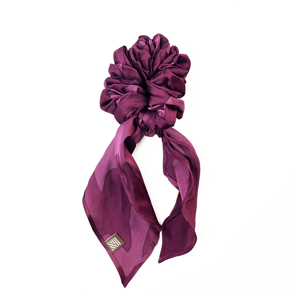Plum Rimba batik scrunchie with ribbon tail on white background.