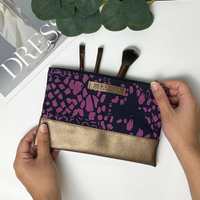 a batik zip pouch in the pattern purple bintik against a neutral background