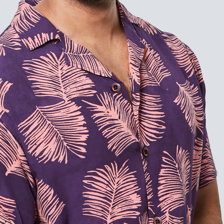 a close-up of man wearing batik shirt in purple sawit pattern