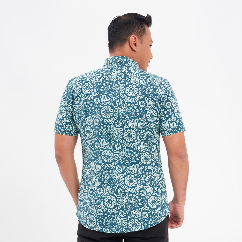 a male model facing away from the camera to highlight the back of the batik shirt in the pattern teal ukir