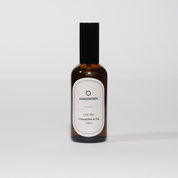 A brown bottle of Linen Mist with a white label that reads 'Mangosteen Linen Mist Osmanthus & Fig 100ml'.