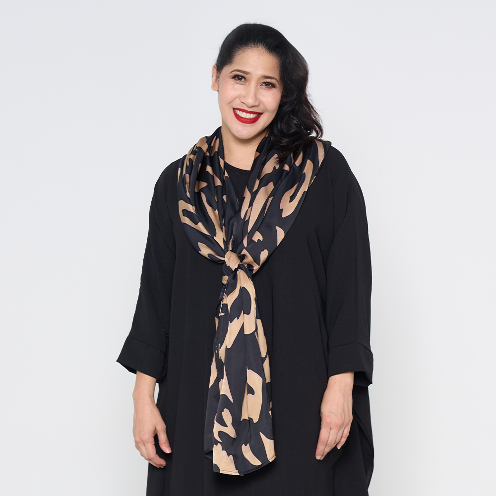 a woman wearing a black rimba scarf against a white background