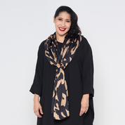 a woman wearing a black rimba scarf against a white background