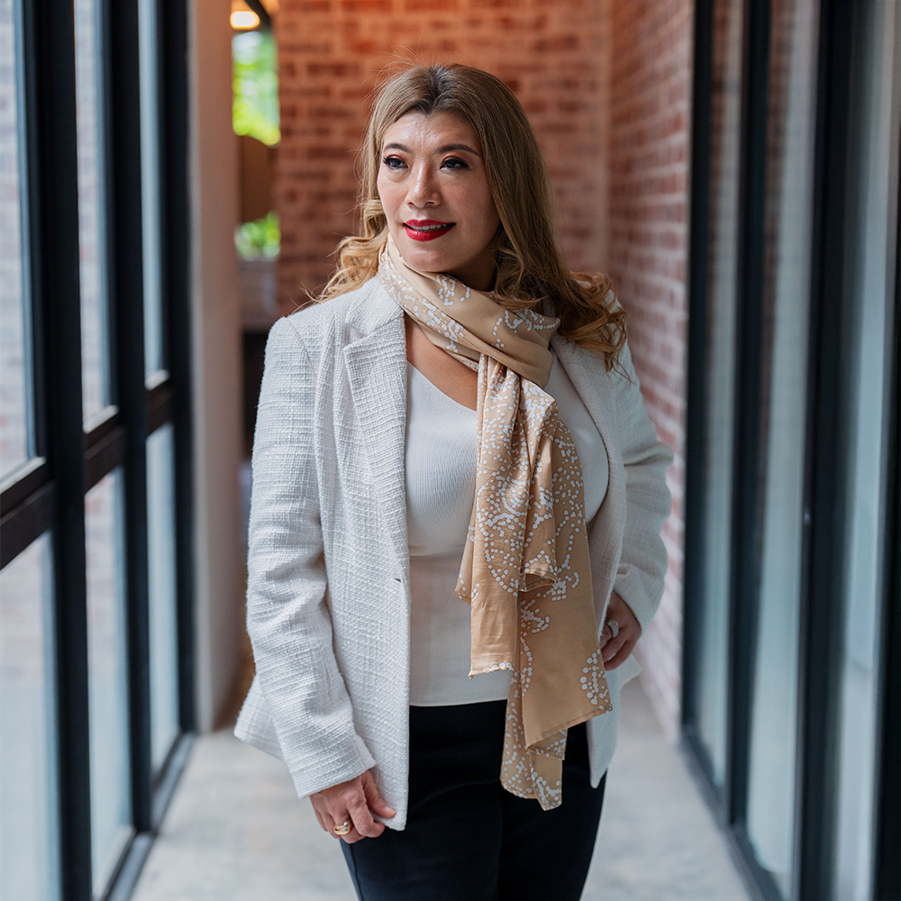 a woman posing in a batik scarf in the pattern tan orchid 