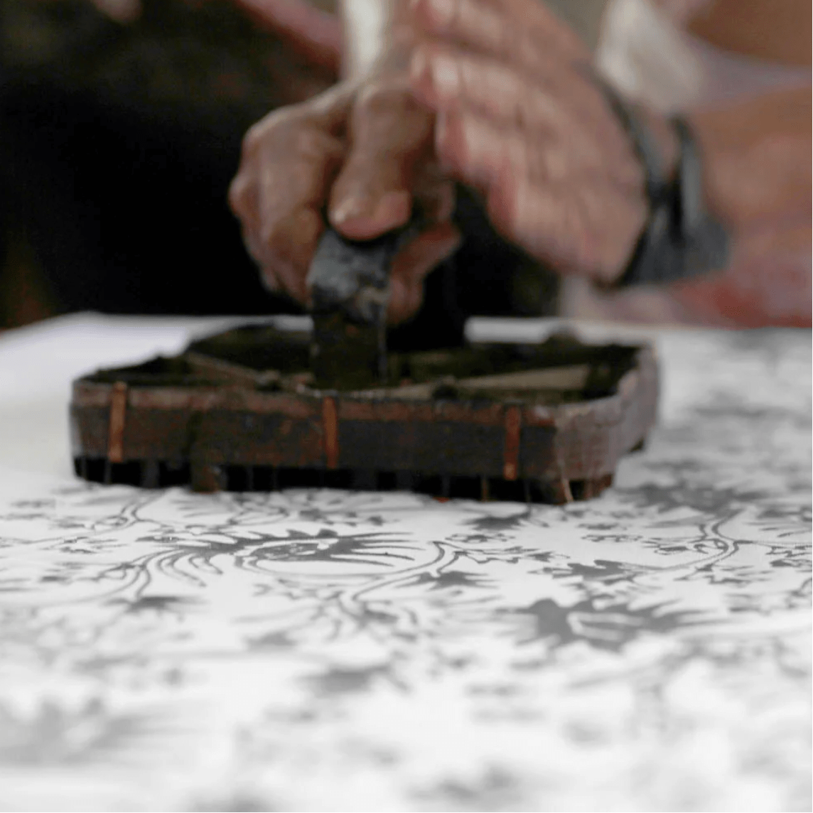 Sage green batik drawstring pouch with white floral motif, handmade by Batik Boutique artisans using traditional batik techniques.