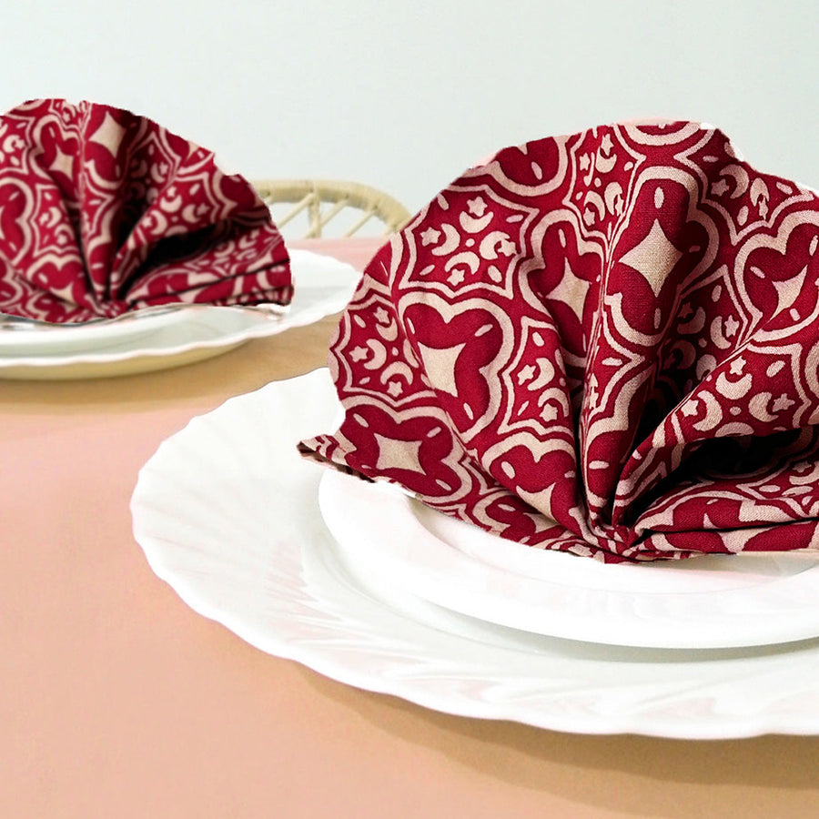 A lifestyle photo of batik serviette set in crimson celestial and put on top of all plates on dining table