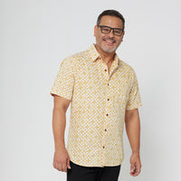 a photo of a male model standing and showcasing the authentic batik shirt in the pattern mustard arabesque
