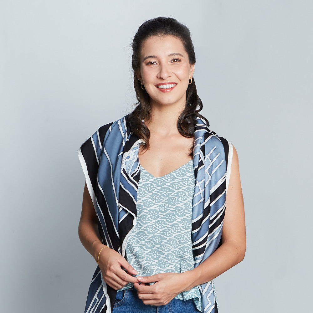 a women standing at white wall styling batik KL inspired scarf in jet arang pattern