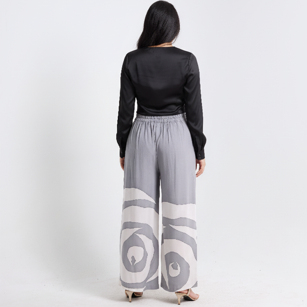 Person wearing a black top and gray patterned pants on a white background