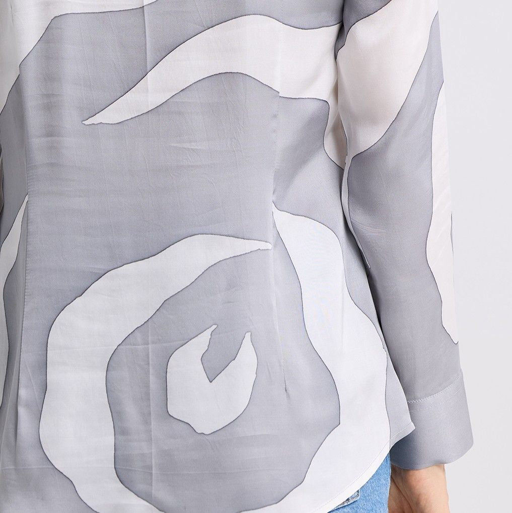 Gray and white abstract patterned shirt with a person wearing it.