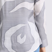 Gray and white abstract patterned shirt with a person wearing it.