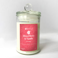 a mixed berry and vanilla scented candle in front of a white wall