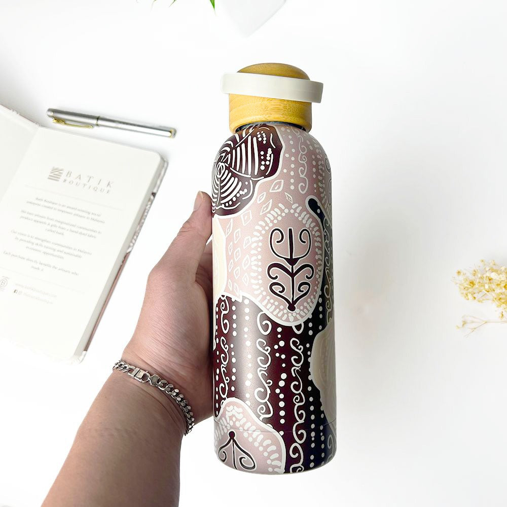 Hand holding a decorated water bottle with a white background