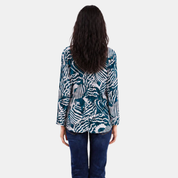 Woman wearing blue printed batik kebaya top, facing the back, showing the features of the backside of the top