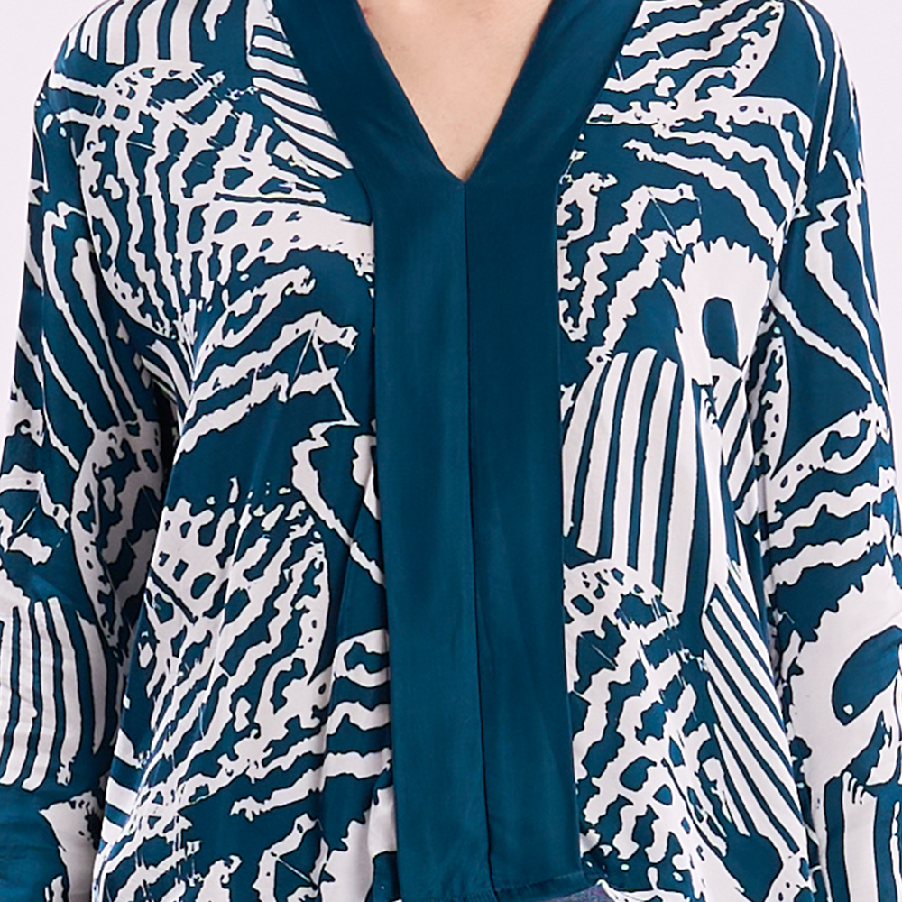 Closeup of kebaya top and blue shell pattern.