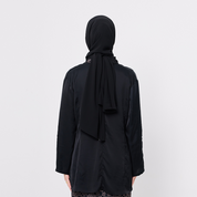 Person wearing a black hijab and black outfit on a white background