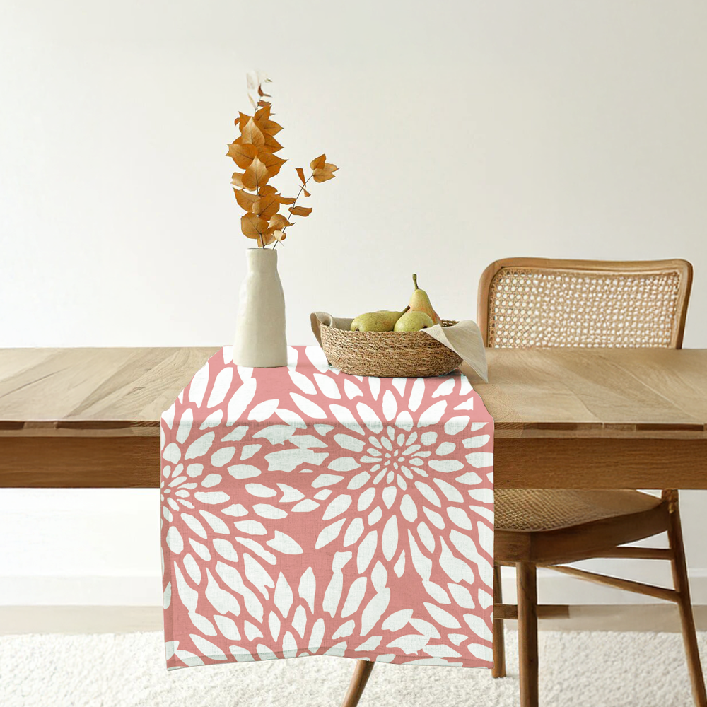 Coral batik table runner with bold white floral motif displayed on a wooden dining table.
