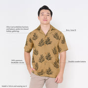 a male model wearing a batik tan olive leaf against a white background