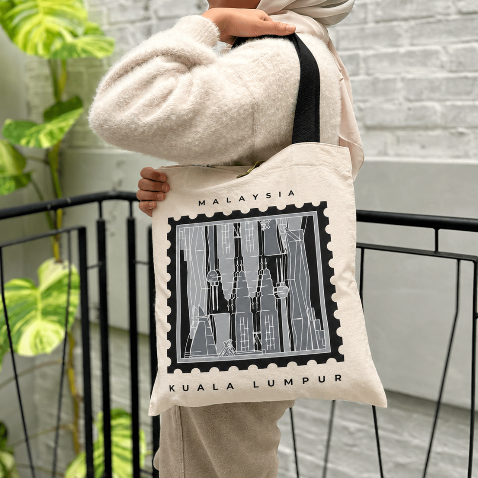 Woman carrying totebag with the Kuala Lumpur print on it, gray-ish tones