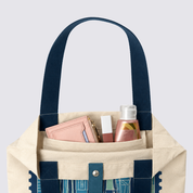Closeup of totebag with blue-ish KL inspired prints, and products inside