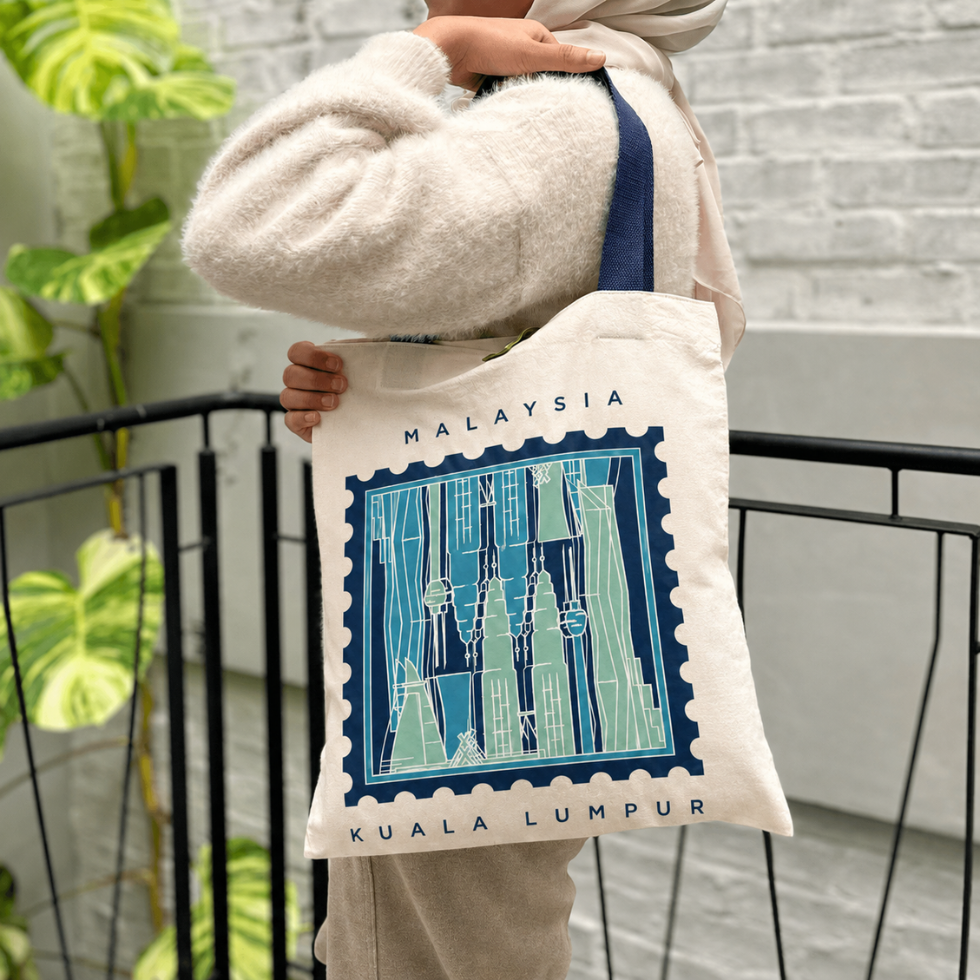 Woman carrying totebag with the Kuala Lumpur print on it, blue-ish tones