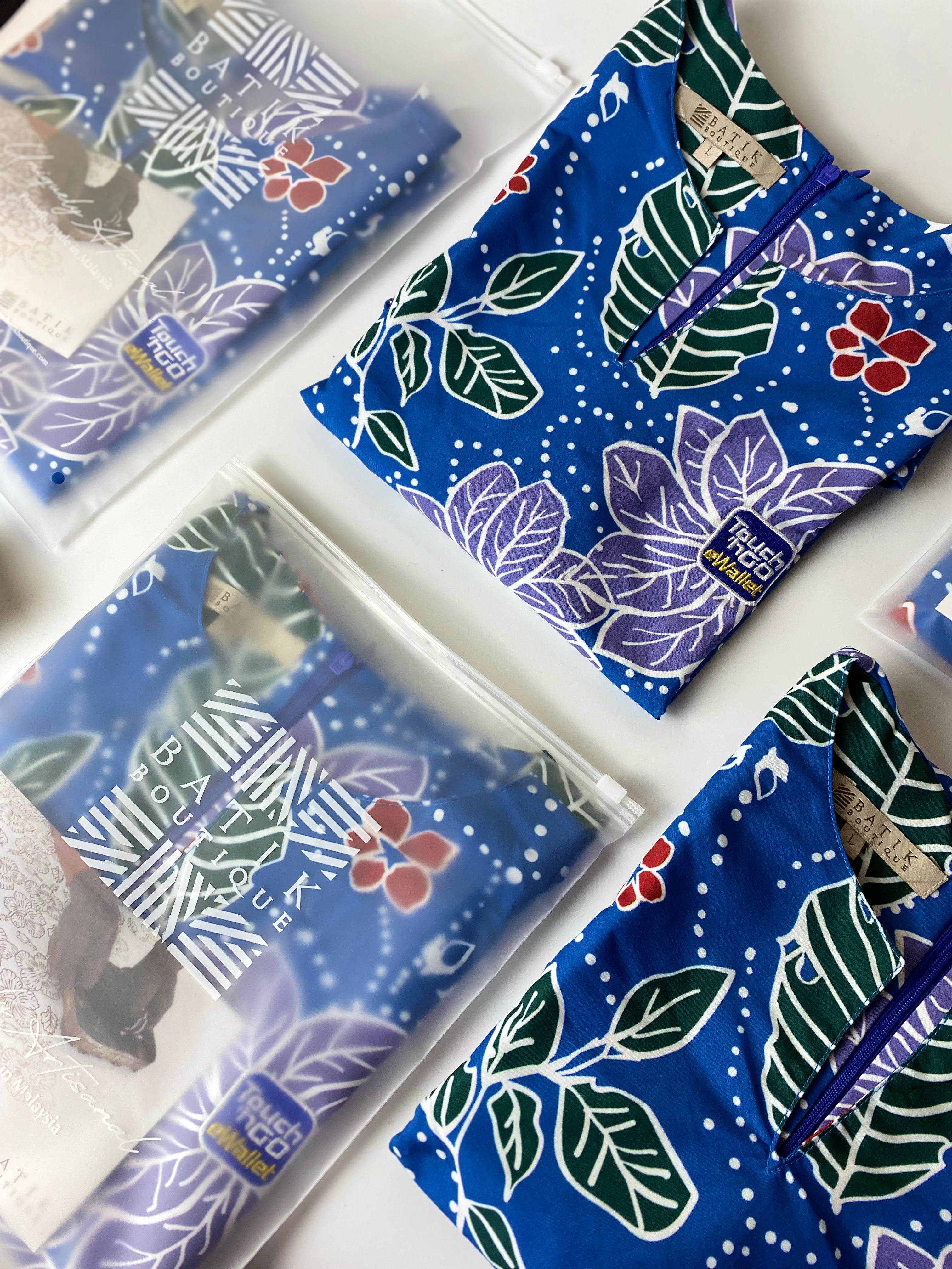 Blue patterned bags with floral and leaf designs on a white surface