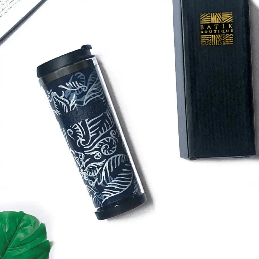 A lifestyle photo featuring a Blue Nautical Fern patterned batik tumbler accompanied by its stylish box, elegantly showcased against a neutral background