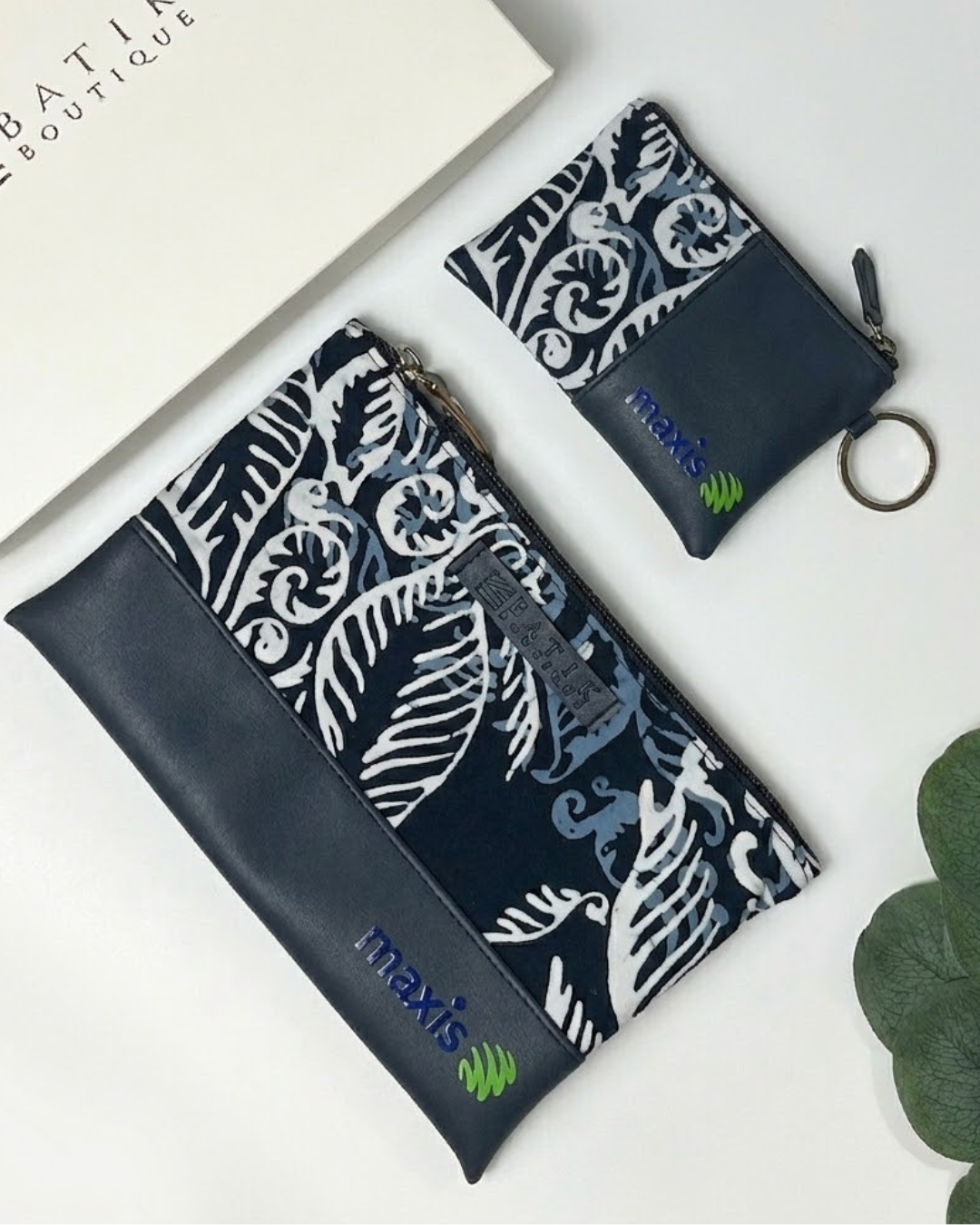 Two navy blue pouches with white patterns and 'maxxis' branding on a light background.