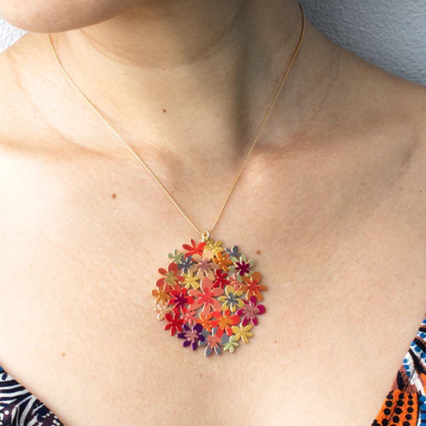 Colorful floral pendant necklace on a person's neck