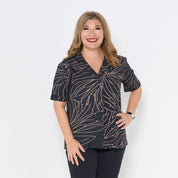 a woman poses in a batik shirt in the pattern onyx palma cuban