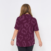 a woman wearing a batik cuban shirt in the pattern plum rimba 