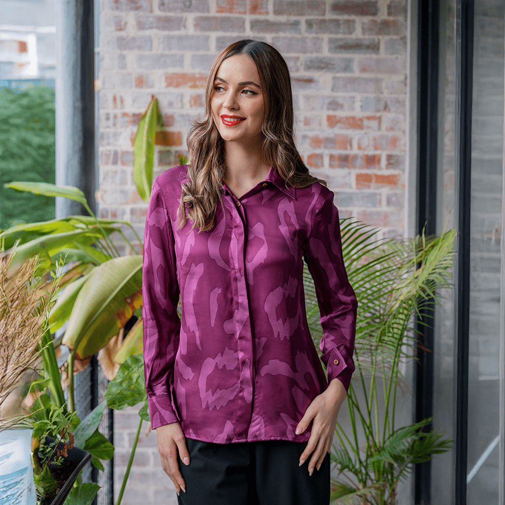 a woman posing in a batik shirt in the pattern plum rimba in a lifestyle photo