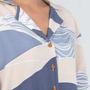 Close-up of a patterned shirt with blue and beige design on a white background