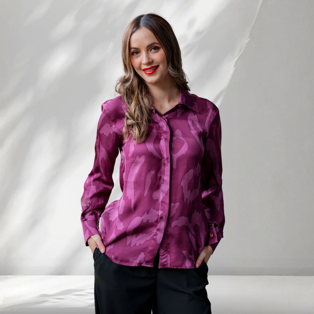 Woman wearing a purple patterned shirt against a white background