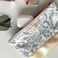 a flatlay photo of batik zip pouch in grey peony pattern 