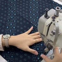 A seamstress is sewing batik fabric in alur pattern