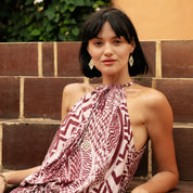 Woman wearing a patterned dress sitting on steps outdoors