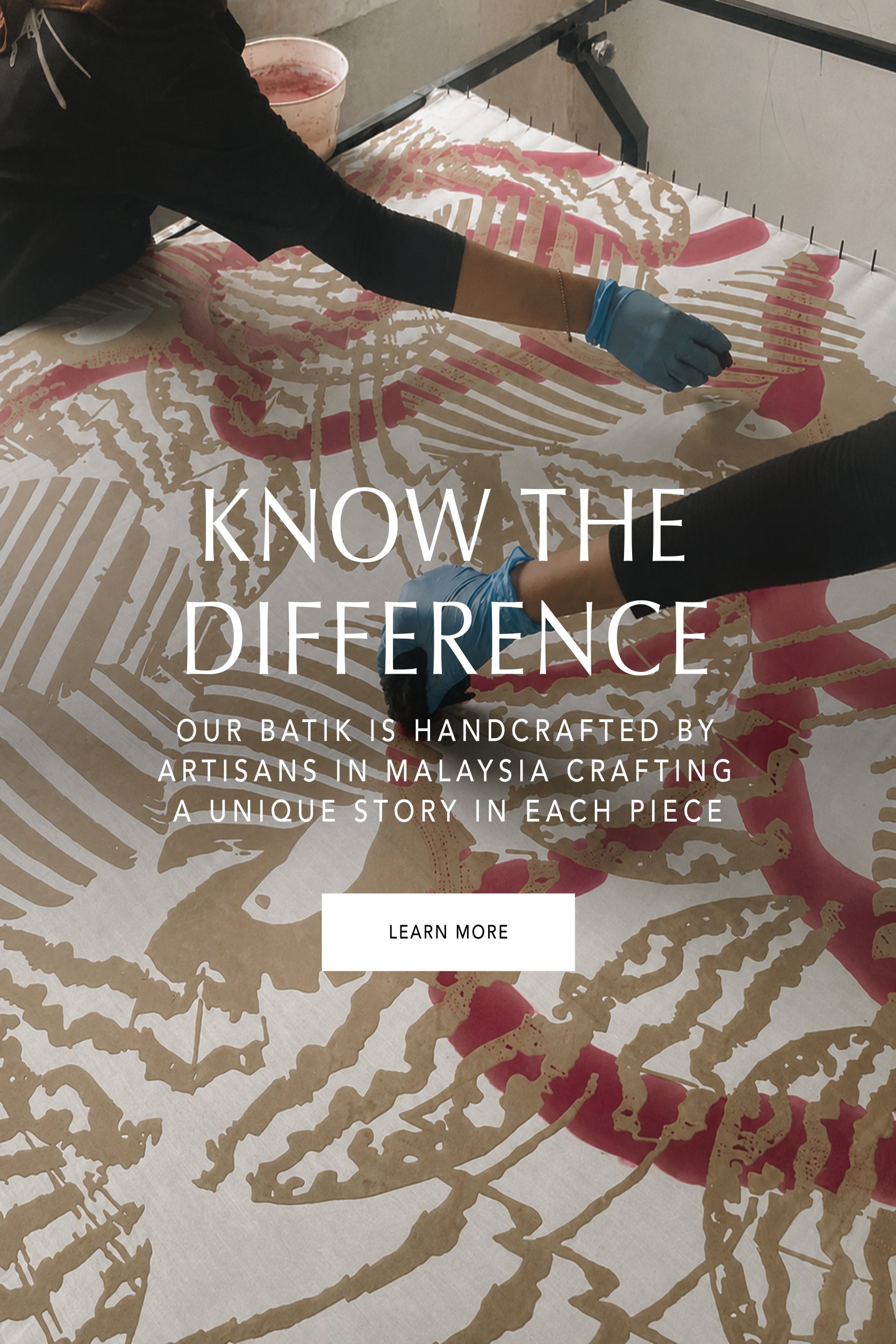Text overlay on batik fabric with hands working on it, promoting handcrafted batik by Malaysian artisans.