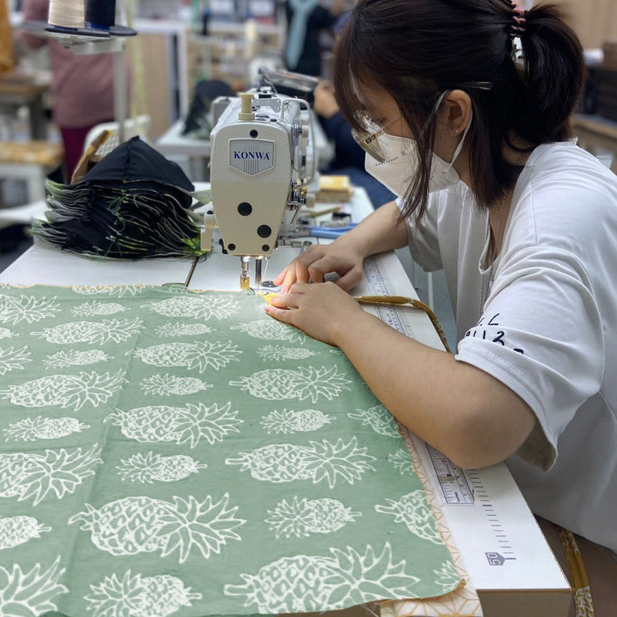 a seamstress sewing olive pineapple