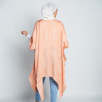 Muslim model facing backwards wearing batik kimono in peach Fern hand printed in Malaysia.