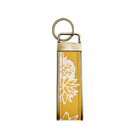 A frontside photo of batik key fob in golden pineapple pattern on a white color background