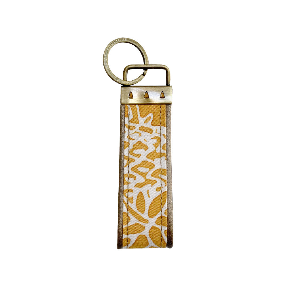 A backside photo of batik key fob in golden pineapple pattern on a white color background